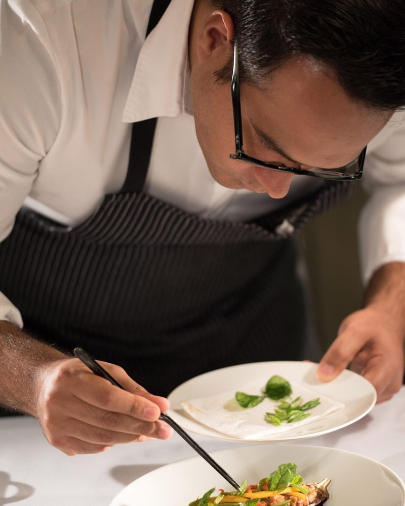 Mains du chef préparant des légumes frais